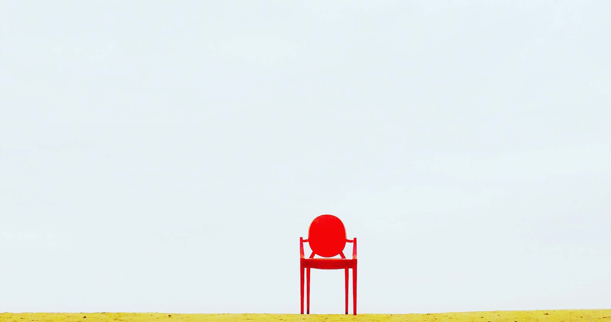 Chaise rouge sur fond bleu clair