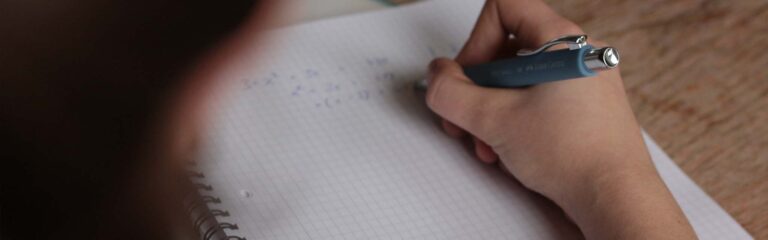 Une femme écrit sur un cahier, elle fait son test technique